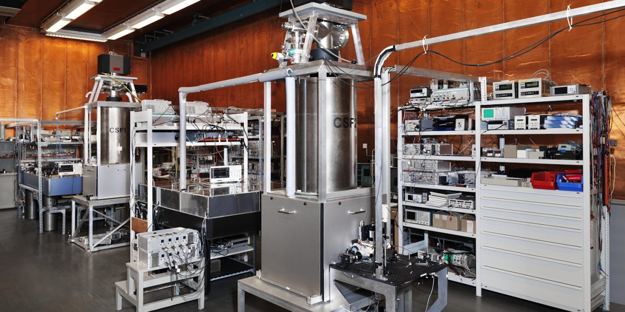 How are atomic clocks refined with AWG cards in PXIe format?